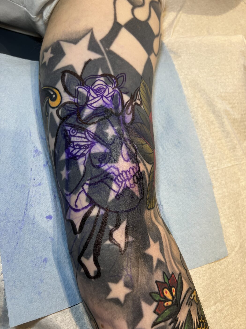 Old dark star-and-checkerboard sleeve stenciled for a cover-up at Broken Art Tattoo